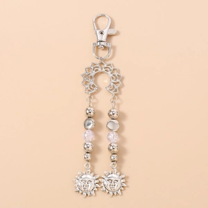 Détail du porte-clés soleil argenté avec perles et pendentif de dieu du soleil gravé