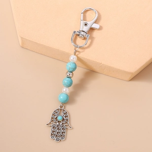 Detailaufnahme des Hamsa-Hand-Anhängers mit Türkisperlen und Perlen am Schlüsselbund