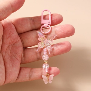 Detailed shot of pink butterfly keychain with iridescent beads and metallic D-ring