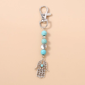 Detailaufnahme des Hamsa-Hand-Anhängers mit Türkisperlen am silbernen Schlüsselbund