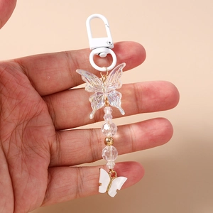 Detail of beaded butterfly keychain featuring iridescent acrylic charm and golden accents