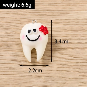 Vista macro di un ciondolo a forma di dente in resina, altezza 3,4cm e larghezza 2,2cm