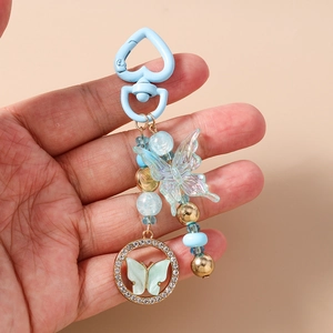 Détail du porte-clés papillon perlé avec clip cœur bleu et accents en cristal brillant
