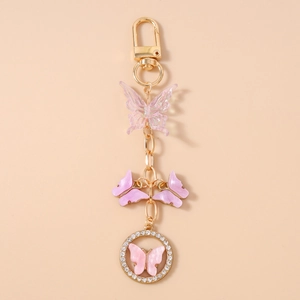 Close-up of pink beaded butterfly keychain with rhinestone ring and gold lobster clasp