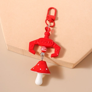 Detail of red mushroom keychain featuring beaded strap and embossed relief buckle