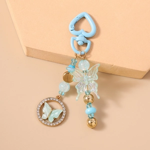Détail du porte-clés papillon avec perles bleues et pendentif cercle en strass