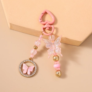 Détail du porte-clés papillon rose avec perles, strass et crochet en forme de cœur