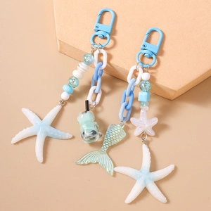 Blue ocean-themed beaded keychain featuring starfish, fish tail and bear charms