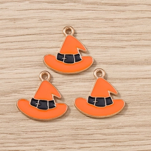 Close-up of orange witch hat charms with gold metal outlines and black bands for DIY jewelry