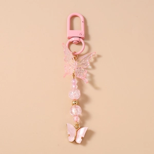 Detail of pink beaded butterfly keychain with acrylic charms and metallic U-shaped clasp