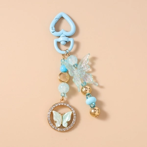 Détail du porte-clés perlé avec pendentif papillon et fermoir cœur bleu élégant