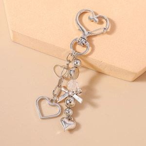 Détail du fermoir mousqueton cœur avec pendentif cœur ajouré et perle en métal argenté