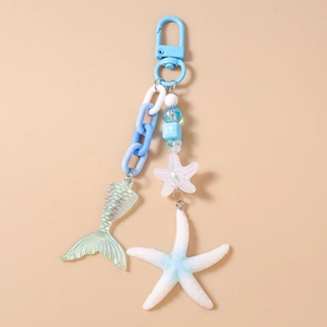 Detail of ocean-themed keychain with blue mermaid tail, starfish charms, and chunky chain