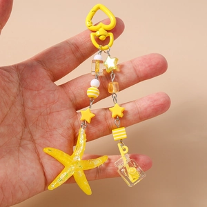 Detail view of yellow starfish and drink bottle charms on a beaded metal keychain
