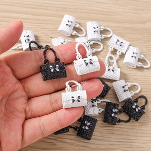 Macro shot of miniature handbag pendants with quilted texture and bow detail