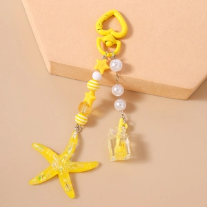 Detail of yellow starfish bag charm with mini juice cup and heart shaped alloy clasp