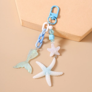 Detailed close-up of blue ocean-themed keychain with resin starfish and fishtail charm