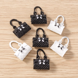 Miniature handbag pendants in black and white with quilted pattern and bow charms