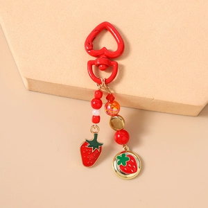 Detail of red strawberry keychain with heart clasp and colorful beaded charms
