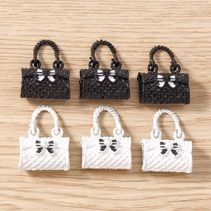 Detailed view of mini resin handbag charms with quilted texture and bow accents