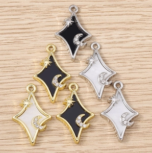 Vue macro de pendentifs étoile et lune sertis de diamants en finitions or et argent