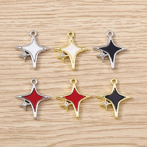 Détail de pendentifs étoile colorés en alliage avec petit zircon sur surface en bois