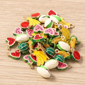 Macro view of colorful fruit and vegetable alloy charms for DIY jewelry making on wood table