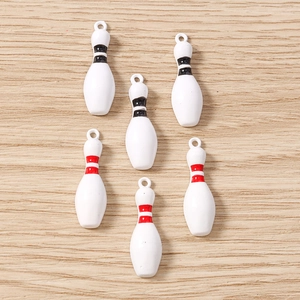 Vue détaillée de breloques de bowling blanches avec anneaux rouges et noirs pour bijoux