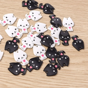 Vue détaillée de breloques chat en émail noir et blanc avec cœurs roses pour bijoux DIY