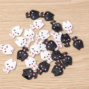 Gros plan de pendentifs chat en émail noir et blanc avec cœur pour bijoux DIY