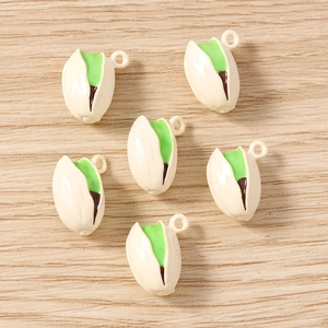 Close-up of pistachio-shaped resin pendants with green kernels for DIY jewelry making
