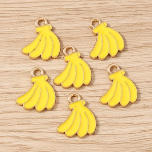 Detail of DIY jewelry findings featuring six yellow banana charms with gold metal rings