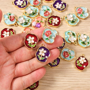 Detailansicht der bunten Emaille-Rosenanhänger mit goldenem Metall-Blumenrahmen