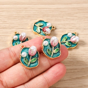 Detail von fünf Blumen-Schmuckanhängern mit rosa Blüten und Perlen für DIY-Projekte