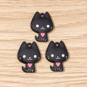 Gros plan de pendentifs chat noir avec cœurs roses pour la création de bijoux