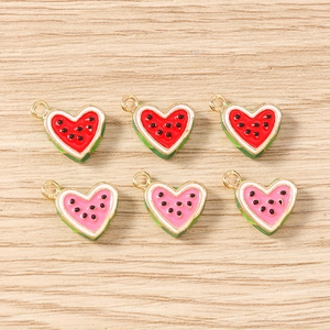 Flat lay of 6 heart-shaped watermelon pendants with enamel details for DIY jewelry making