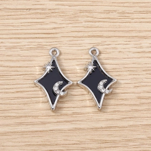 Détail de breloques losanges en argent avec étoile, lune, émail noir et strass