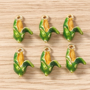 Detailed close-up of six enamel corn charms with golden rings for DIY jewelry making