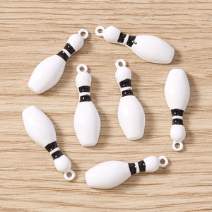 Gros plan détaillé de pendentifs quilles de bowling blancs pour bijoux DIY et artisanat