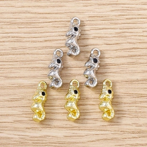 Vue détaillée de breloques hippocampe or et argent pour bijoux DIY sur fond bois