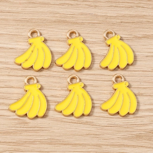 Detail of banana enamel pendants for jewelry making with gold-plated metal edges