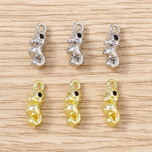 Gros plan de breloques hippocampe en or et argent pour bijoux DIY sur fond de bois
