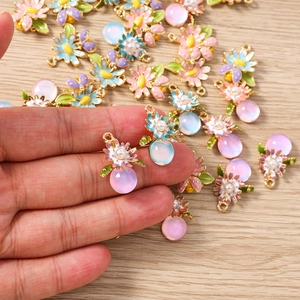 Détail macro de pendentifs fleurs en émail avec perles et billes translucides pour bijoux DIY