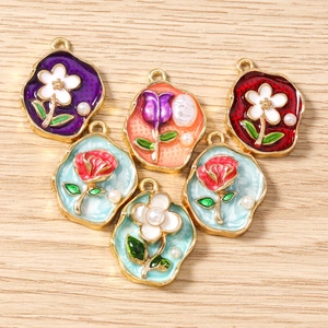 Makroaufnahme bunter Emaille-Blumenanhänger mit Vergoldung und Perlen für DIY-Schmuck