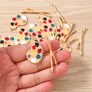 Détails macro de breloques en alliage palette et pinceaux pour bijoux DIY