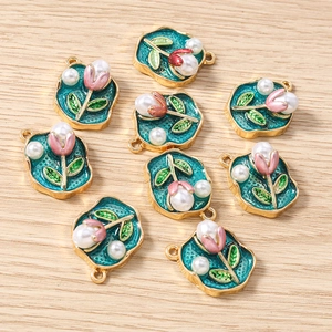 Detail von 9 blaugrünen Emaille-Blumenanhängern mit Perlen und Goldkante für DIY-Schmuck