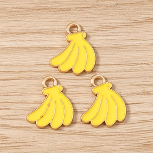 Close-up of three yellow enamel banana charms with gold metal edges for DIY jewelry making