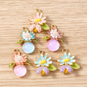Détail des pendentifs émaillés animaux et fleurs aux couleurs macaron et perles