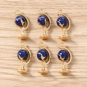Detailed macro view of six blue enamel globe charms with gold rings for DIY jewelry