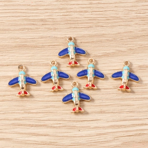 Macro view of blue airplane enamel charms for DIY jewelry making and keychains